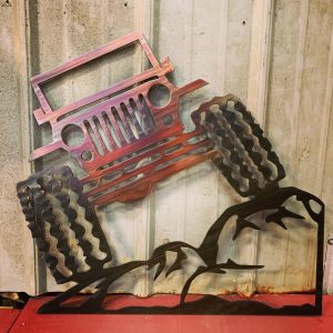 Metal wall art depicting a Jeep climbing rock with a Multi-Color Patina finish on the metal.