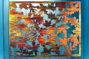 Metal wall art depicting fall leaves on metal cut square.