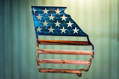 Metal wall art depicting an outline of the state of Georgia with American Flag across the outline of the state.