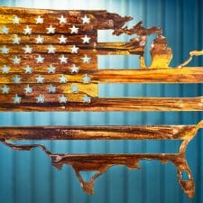 Metal wall art depicting American Flag inside outline of United States cut out of metal finished with Wood Grain Copper Patina