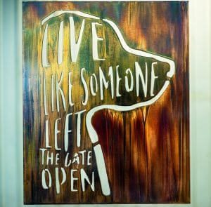 Live Like Someone Let The Gate Open metal wall decor depicts the saying next to a silhouette of a dog
